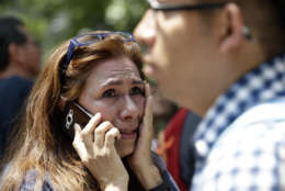A woman tries to reach people on her cellphone after she evacuated with others to Paseo de la Reforma street after an earthquake in Mexico City, Tuesday, Sept. 19, 2017. A powerful earthquake jolted central Mexico on Tuesday, causing buildings to sway sickeningly in the capital on the anniversary of a 1985 quake that did major damage. (AP Photo/Marco Ugarte)