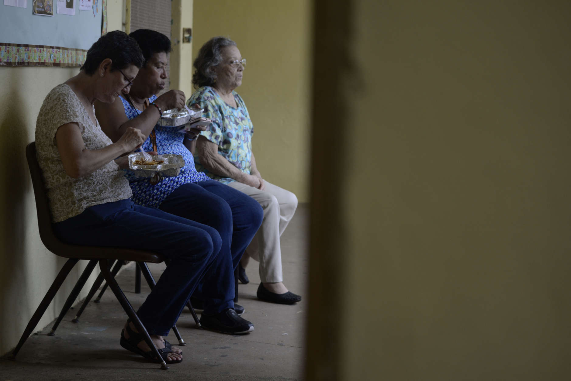 Women eat at the Juan Ponce de Leon Elementary School before the arrival of Hurricane Maria, in Humacao, Puerto Rico, Tuesday, Sept. 19, 2017. Puerto Rico is likely to take a direct hit by the category 5 hurricane. Authorities warned people who live in wooden or flimsy homes should find safe shelter before the storm's expected arrival on Wednesday. (AP Photo/Carlos Giusti)