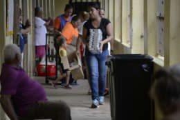 A woman passes out trays of food to evacuees taking shelter at the Juan Ponce de Leon Elementary School before the arrival of Hurricane Maria, in Humacao, Puerto Rico, Tuesday, Sept. 19, 2017. Puerto Rico is likely to take a direct hit by the category 5 hurricane. Authorities warned people who live in wooden or flimsy homes should find safe shelter before the storm's expected arrival on Wednesday. (AP Photo/Carlos Giusti)