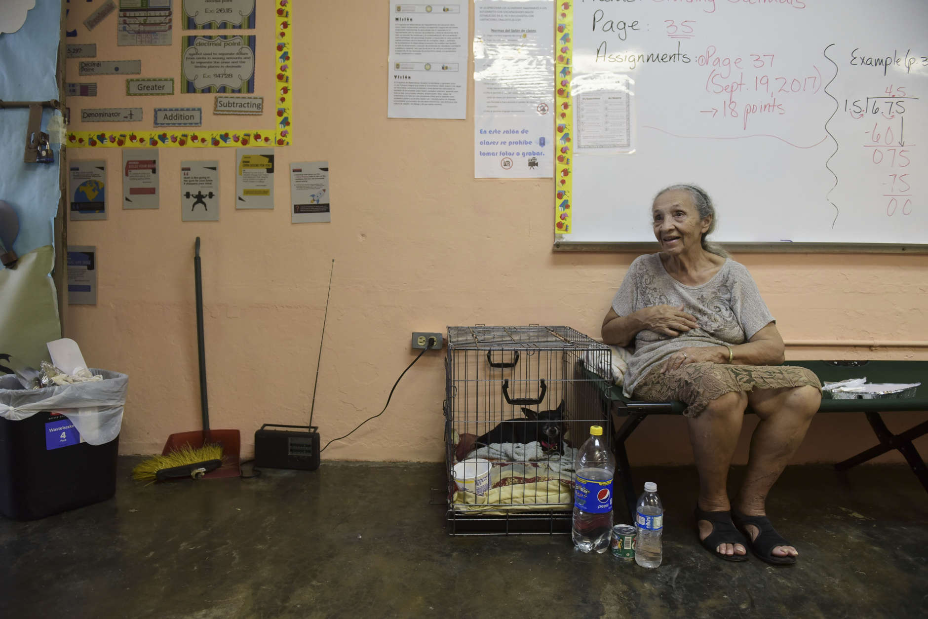 Evacuee Guillermina Reyes, 90, sits with with her pet dog Blackie at the Juan Ponce de Leon Elementary School before the arrival of Hurricane Maria, in Humacao, Puerto Rico, Tuesday, Sept. 19, 2017. Puerto Rico is likely to take a direct hit by the category 5 hurricane. Authorities warned people who live in wooden or flimsy homes should find safe shelter before the storm's expected arrival on Wednesday. (AP Photo/Carlos Giusti)