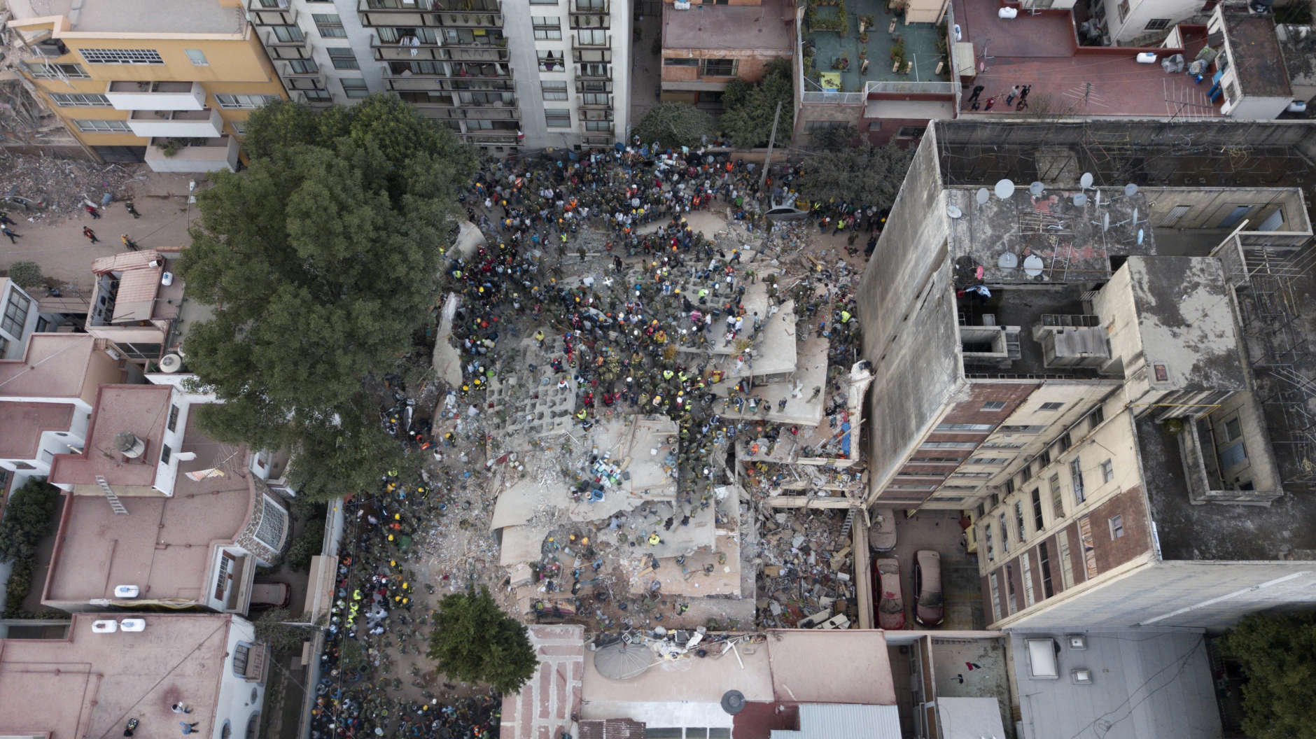 Rescue workers and volunteers search for survivors on a collapsed building the Del Valle neighborhood in Mexico City, Tuesday Sept. 19, 2017. A magnitude 7.1 earthquake has stunned central Mexico, killing more than 100 people as buildings collapsed in plumes of dust. (AP Photo/Miguel Tovar)