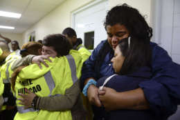 Rescue team members Candida Lozada, left, and Stephanie Rivera, second from left, Mary Rodriguez, left at right side, and Zuly Ruiz, right at right side, merge into a hug desperate to go out to attend several calls for help from citizens in need of assistance during the impact of Maria, a Category 5 hurricane that started to hit the eastern region of the island, in Humacao, Puerto Rico, Tuesday, Sept. 20, 2017. At that point, Maria downgraded to a category 4 hurricane. (AP Photo/Carlos Giusti)