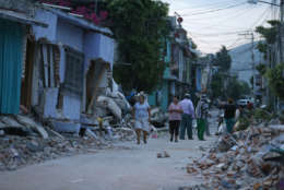 Residents stand next to buildings damaged by a 7.1 earthquake, in Jojutla, Morelos state, Mexico, Wednesday, Sept. 20, 2017. Police, firefighters and ordinary Mexicans are digging frantically through the rubble of collapsed schools, homes and apartment buildings, looking for survivors of Mexico's deadliest earthquake in decades as the number of confirmed fatalities climbed to 248. (AP Photo/Eduardo Verdugo)