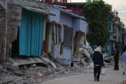 A man walks past homes damaged by a 7.1 earthquake, in Jojutla, Morelos state, Mexico, Wednesday, Sept. 20, 2017. Police, firefighters and ordinary Mexicans are digging frantically through the rubble of collapsed schools, homes and apartment buildings, looking for survivors of Mexico's deadliest earthquake in decades as the number of confirmed fatalities climbed to 248. (AP Photo/Eduardo Verdugo)