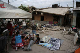 A family set up shelter in the middle of a street next to homes damaged by a 7.1 earthquake, in Jojutla, Morelos state, Mexico, Wednesday, Sept. 20, 2017. Police, firefighters and ordinary Mexicans are digging frantically through the rubble of collapsed schools, homes and apartment buildings, looking for survivors of Mexico's deadliest earthquake in decades as the number of confirmed fatalities climbed to 248. (AP Photo/Eduardo Verdugo)