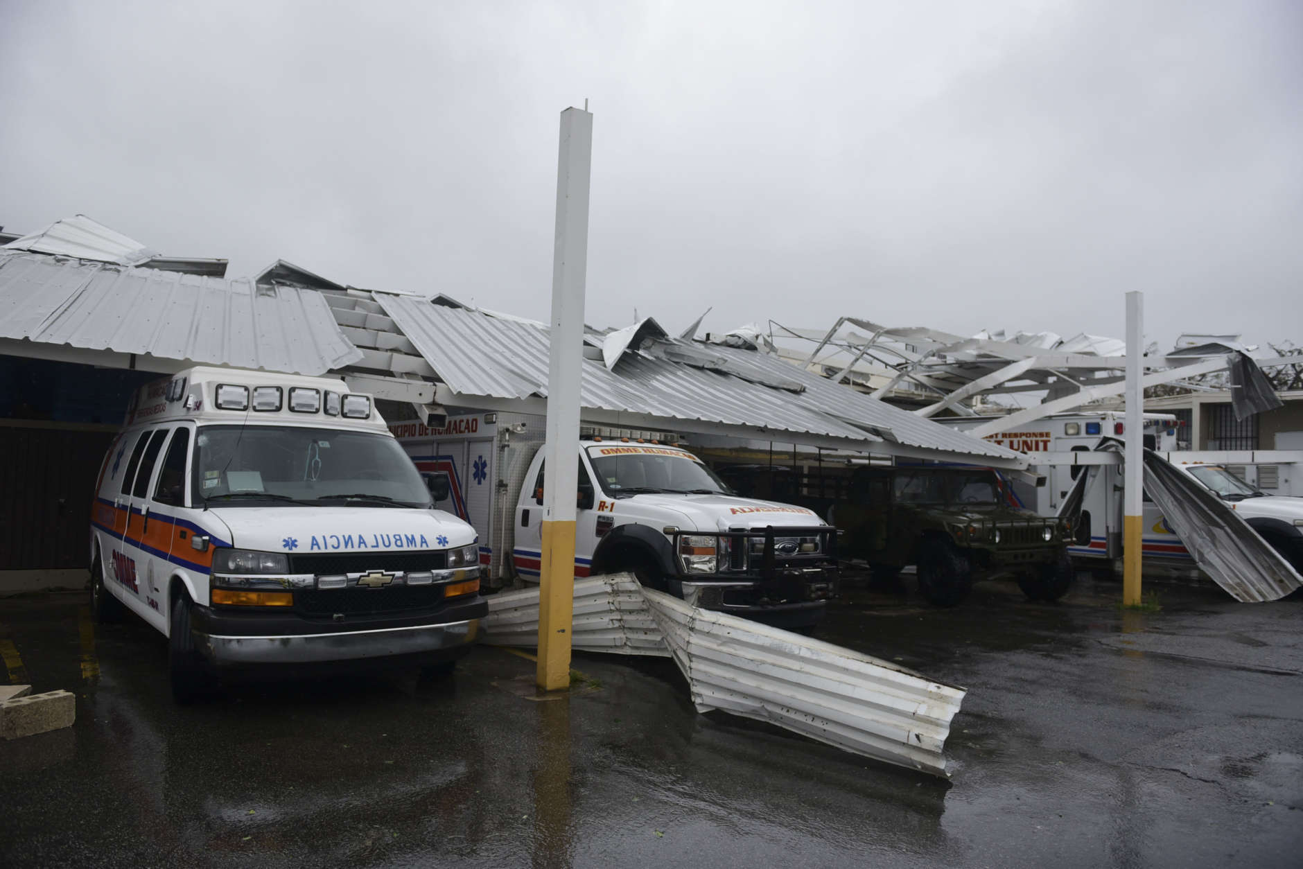 Rescue vehicles from the Emergency Management Agency stand trapped under an awning during the impact of Hurricane Maria, which hit the eastern region of the island, in Humacao, Puerto Rico, Wednesday, Sept. 20, 2017. The U.S. National Hurricane Center says Maria has lost its major hurricane status, after raking Puerto Rico. But forecasters say some strengthening is in the forecast and Maria could again become a major hurricane by Thursday. (AP Photo/Carlos Giusti)