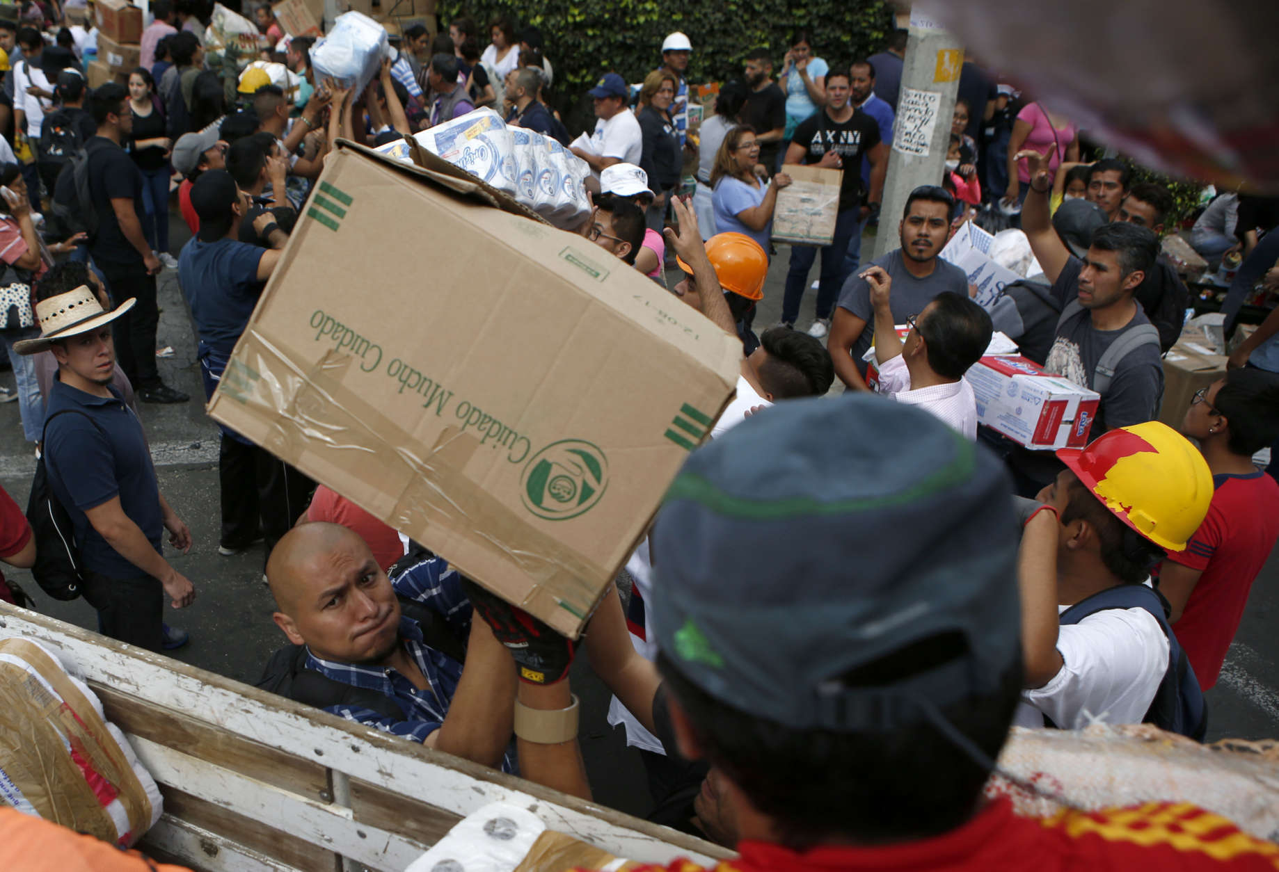 Volunteers load emergency supplies to be taken to another earthquake stricken area, in the Linda Vista neighborhood of Mexico City, Wednesday, Sept. 20, 2017. People by the millions rushed from homes and offices across central Mexico, after a 7.1 earthquake, sometimes watching as buildings they had just fled fell behind them with an eruption of dust and debris. (AP Photo/Rebecca Blackwell)