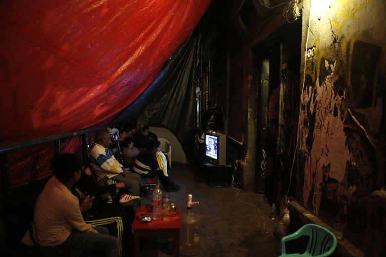 Five families watch tv and prepare to sleep under tarps on the sidewalk outside their earthquake damaged building in the Roma neighborhood of Mexico City, Wednesday, Sept. 20, 2017. Residents said inspectors declared their building unsafe and the fifteen families who lived there are either camping out front or have gone to stay with relatives. Pointing to decades of neglect by the building's rental corporation, they say they will camp out indefinitely, insisting that the government recognize their rights to the property and provide them a suitable place to live.(AP Photo/Rebecca Blackwell)