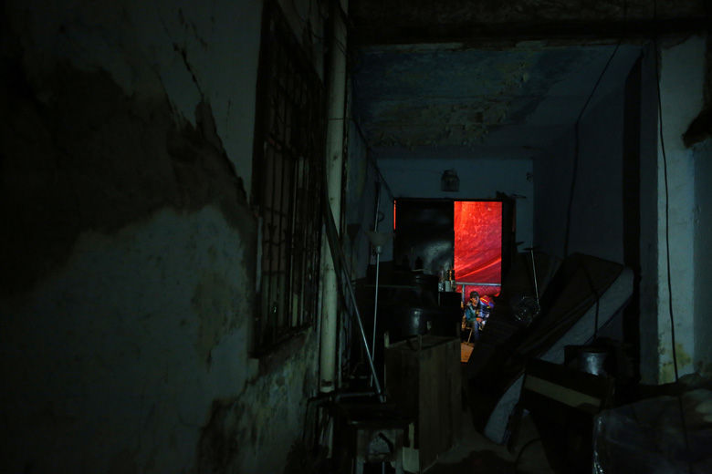 A man watching tv on the sidewalk outside is seen from inside the earthquake damaged building where 15 families live, in the Roma neighborhood of Mexico City, Wednesday, Sept. 20, 2017. Building residents said inspectors declared their building unsafe and the fifteen families who lived there are either camping out front of the building or have gone to stay with relatives. Pointing to decades of neglect by the building's rental corporation, they say they will camp out indefinitely, insisting that the government recognize their rights to the property and provide them a suitable place to live.(AP Photo/Rebecca Blackwell)