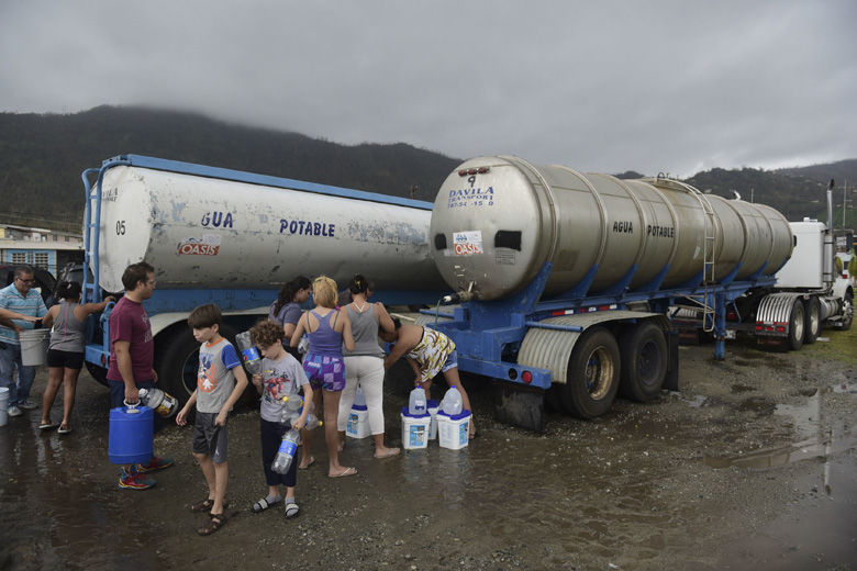 Locals arrive at a water collection point a day after the impact of Hurricane Maria, in Yabucoa, Puerto Rico, Thursday, September 21, 2017. As of Thursday evening, Maria was moving off the northern coast of the Dominican Republic with winds of 120 mph (195 kph). The storm was expected to approach the Turks and Caicos Islands and the Bahamas late Thursday and early Friday. (AP Photo/Carlos Giusti)