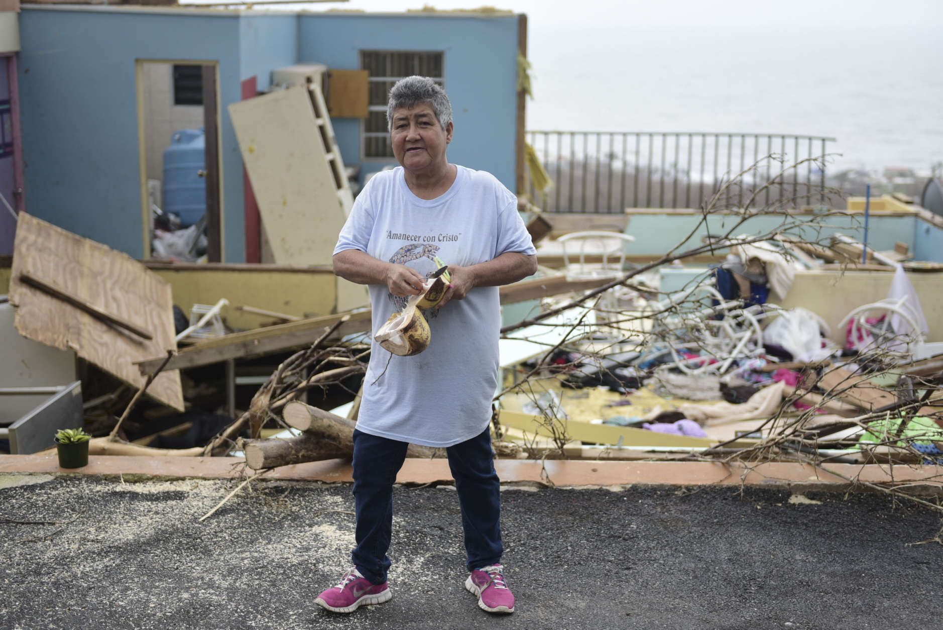 "Whats important is ones life" says Rufina Fernandez standing in front of her daughters ruined house while eating a coconut a day after the impact of Hurricane Maria, in Yabucoa, Puerto Rico, Thursday, September 21, 2017. As of Thursday evening, Maria was moving off the northern coast of the Dominican Republic with winds of 120 mph (195 kph). The storm was expected to approach the Turks and Caicos Islands and the Bahamas late Thursday and early Friday. (AP Photo/Carlos Giusti)