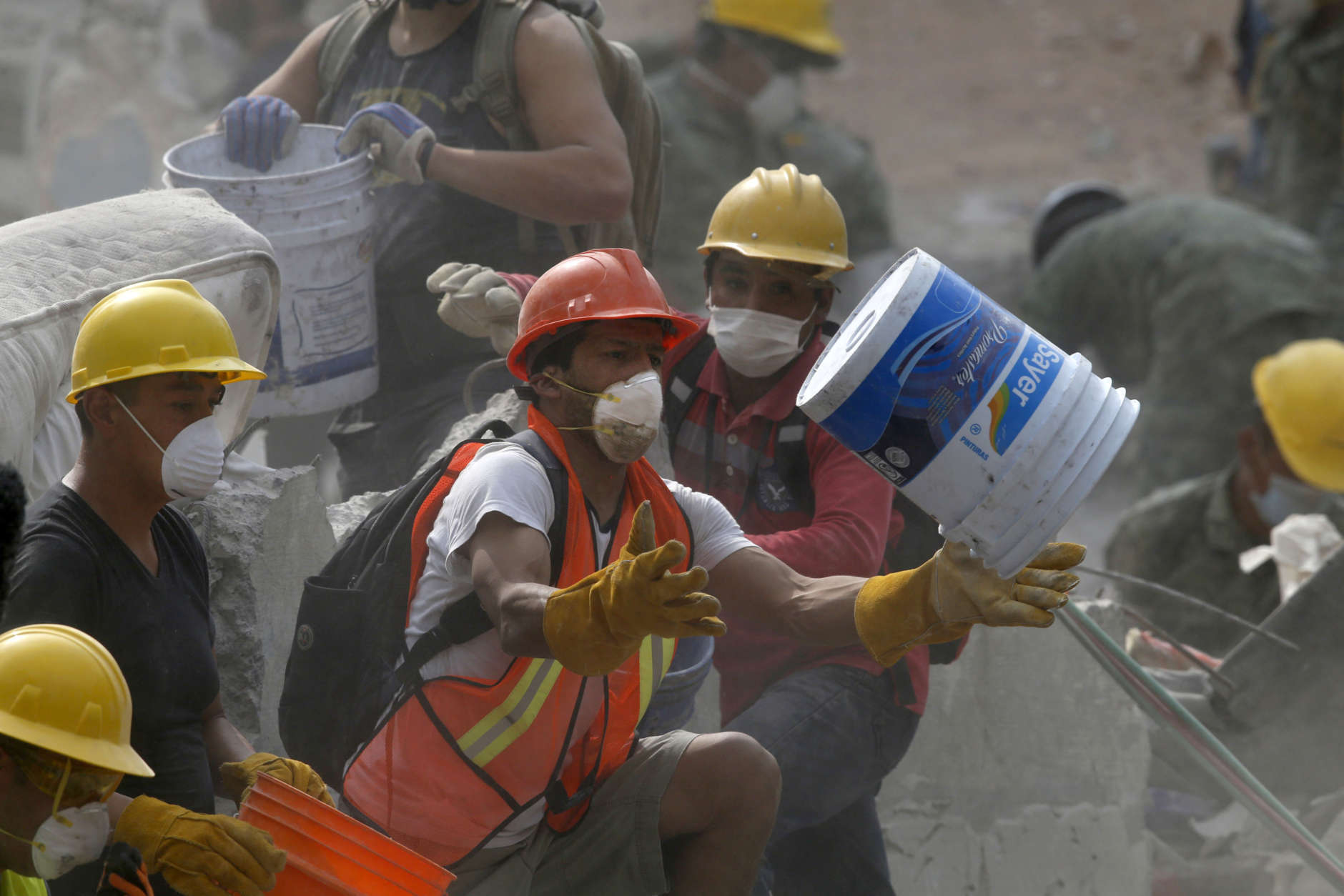A volunteer catches a bucket during rescue efforts at a collapsed building in La Condesa neighborhood of Mexico City, Thursday, Sept. 21, 2017. Thousands of professionals and volunteers are working frantically at dozens of wrecked buildings across the capital and nearby states looking for survivors of the powerful quake that hit Tuesday. (AP Photo/Marco Ugarte)