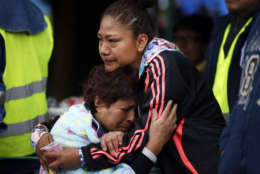 Family members embrace as they wait for news of their relatives outside a quake-collapsed seven-story building in Mexico City's Roma Norte neighborhood, Friday, Sept. 22, 2017. Mexican officials are promising to keep up the search for survivors as rescue operations stretch into a fourth day following Tuesday's major earthquake that devastated Mexico City and nearby states. (AP Photo/Rebecca Blackwell)