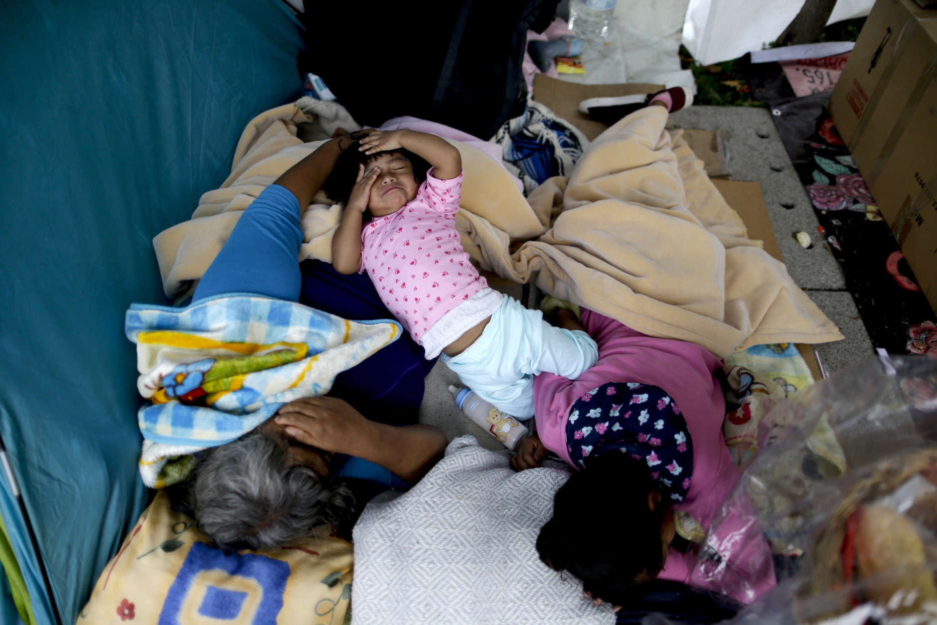 A family sleeps on a square after being displaced from their home due to the risk of collapse, in the aftermath of a 7.1 earthquake, in Mexico City, Friday, Sept. 22, 2017. Those who witnessed buildings collapse said the tragedy could have been much worse. Some buildings didn't fall immediately, giving people time to escape, and some shattered but left airspaces where occupants survived. (AP Photo/Natacha Pisarenko)