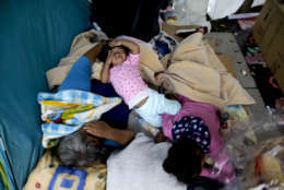 A family sleeps on a square after being displaced from their home due to the risk of collapse, in the aftermath of a 7.1 earthquake, in Mexico City, Friday, Sept. 22, 2017. Those who witnessed buildings collapse said the tragedy could have been much worse. Some buildings didn't fall immediately, giving people time to escape, and some shattered but left airspaces where occupants survived. (AP Photo/Natacha Pisarenko)