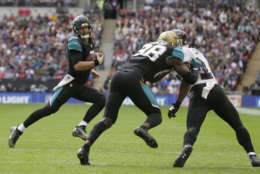 Jacksonville Jaguars quarterback Blake Bortles, left, runs with the ball during the first half of an NFL football game against the Baltimore Ravens at Wembley Stadium in London, Sunday Sept. 24, 2017. (AP Photo/Tim Ireland)