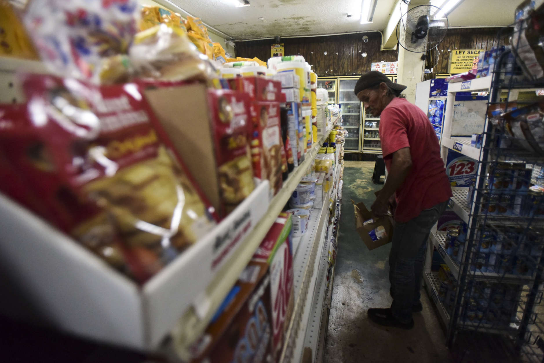 Residents from Juana Matos buy groceries at Catano Mini Market in the middle of a supply shortage caused by the passage of Hurricane Maria, in Catano, Puerto Rico, Wednesday, Sept. 27, 2017. The aftermath of the powerful storm has resulted in a near-total shutdown of the Puerto Rican economy that could last for weeks and has many people running seriously low on cash and deeply concerned that it will become even harder to survive on this storm-ravaged island. (AP Photo/Carlos Giusti)