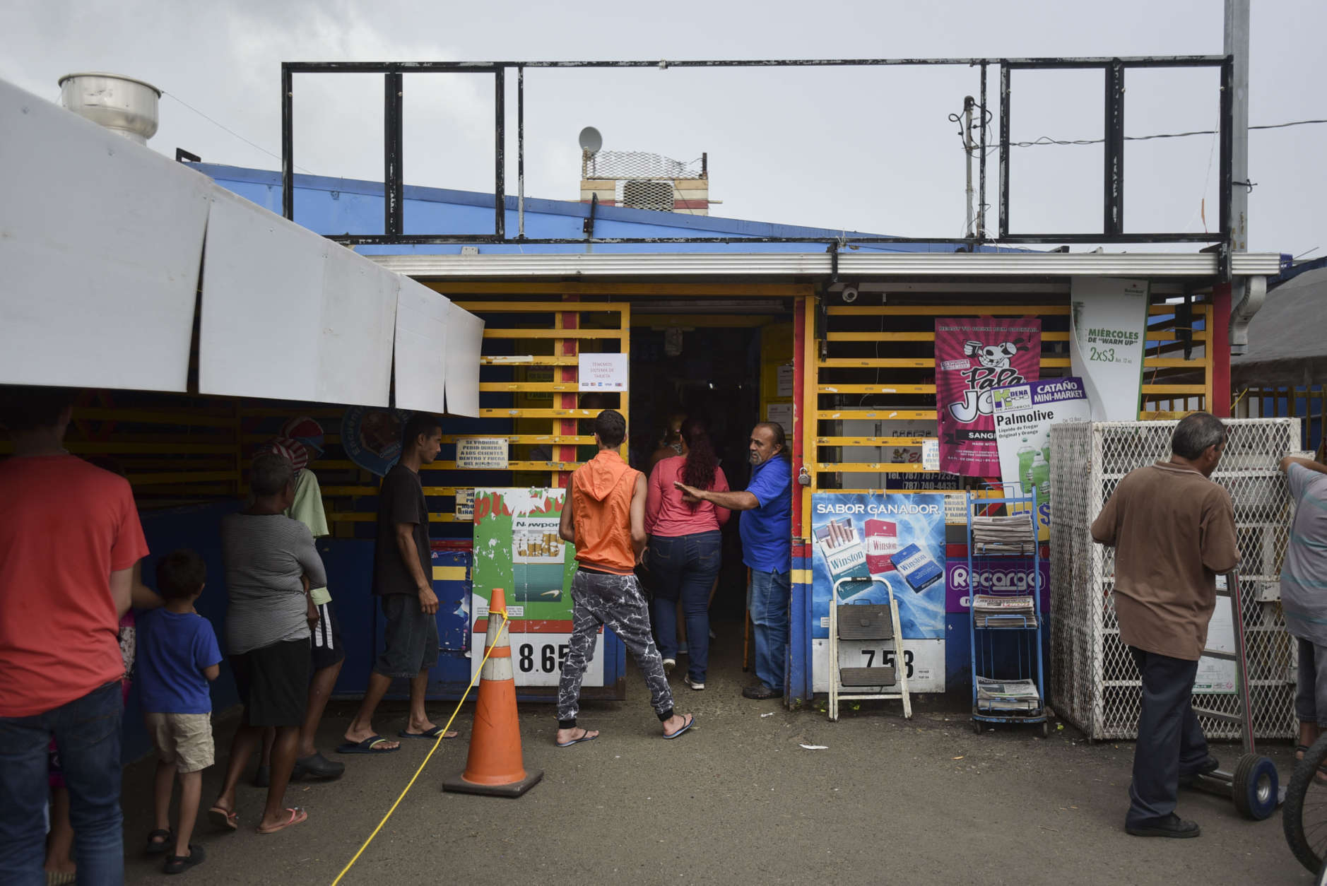 Residents from Juana Matos wait in line to buy groceries at Catano Mini Market in the middle of a supply shortage caused by the passage of Hurricane Maria, in Catano, Puerto Rico, Wednesday, September 27, 2017. The aftermath of the powerful storm has resulted in a near-total shutdown of the Puerto Rican economy that could last for weeks and has many people running seriously low on cash and deeply concerned that it will become even harder to survive on this storm-ravaged island. (AP Photo/Carlos Giusti)