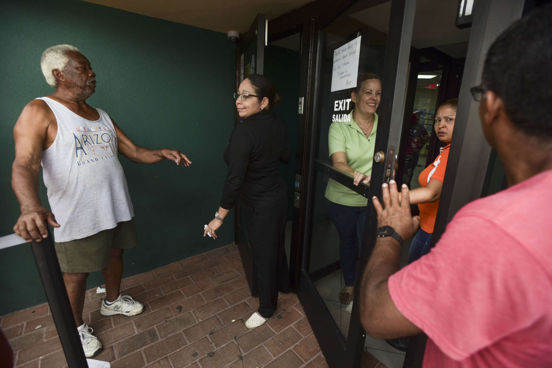 Clients of Coopaca Coperative wait in line to withdraw cash from their accounts after the passage of Hurricane Maria a week ago, in Catano, Puerto Rico, Wednesday, Sept. 27, 2017. The cooperative only granted 200 turns to remove a maximum of one hundred dollars per customer. (AP Photo/Carlos Giusti)