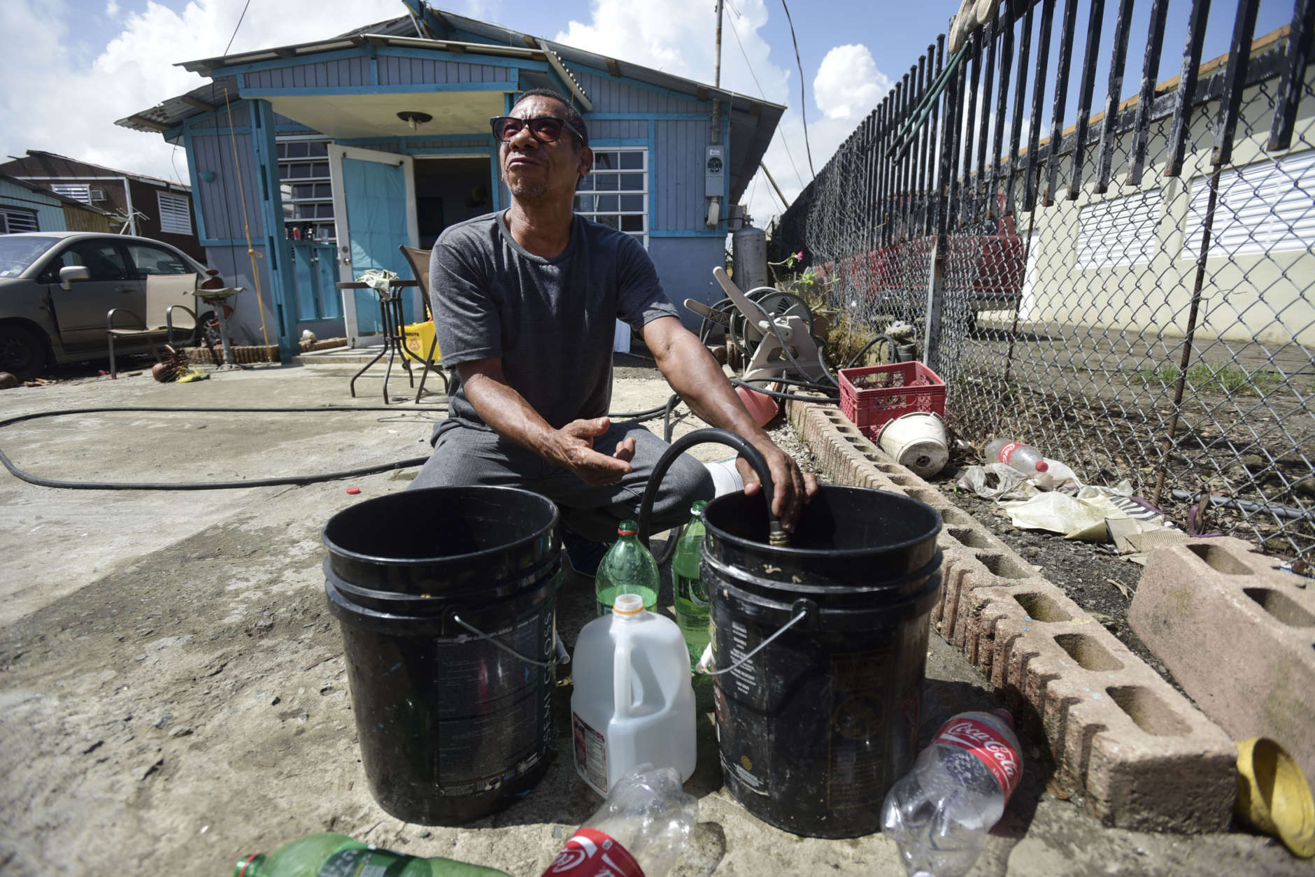 Toa Alta resident Jose Ramos fills buckets with water at a family member's home in the Juana Matos community one week after Hurricane Maria hit Catano, Puerto Rico, Thursday, Sept. 28, 2017. The aftermath of the powerful storm has resulted in a near-total shutdown of the U.S. territory’s economy that could last for weeks and has many people running seriously low on cash and worrying that it will become even harder to survive on this storm-ravaged island. (AP Photo/Carlos Giusti)