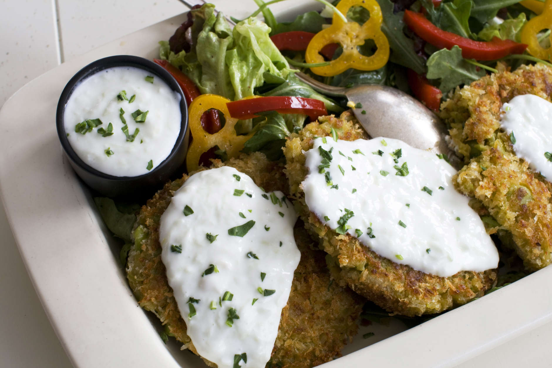 This March 25, 2013 photo taken in Concord, N.H., shows a recipe for Fava Bean Falafel Burger topped with a cucumber yogurt sauce. Falafel are deep-fried fritters made from ground chickpeas or fava beans. (AP Photo/Matthew Mead)