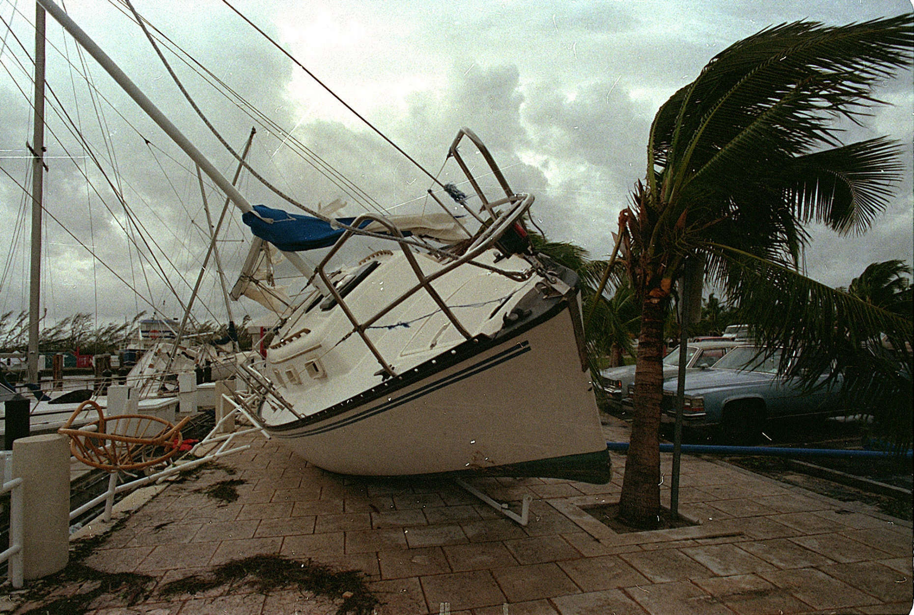 FILE - In this Aug. 24, 1992 file photo, a sailboat sits on a sidewalk at Dinner Key in Miami after it was washed ashore by Hurricane Andrew. Several days after it almost dissipated, Andrew rapidly strengthened and was a Category 4 storm at landfall in Homestead, Fla. The Hurricane Center measured a peak wind gust of 164 mph. Andrew continued into the Gulf of Mexico before reaching the central Louisiana coast as a Category 3 hurricane. Andrew was blamed for 23 deaths in the U.S. and three deaths in the Bahamas and caused an estimated $26.5 billion in damage in the United States. (AP Photo/Terry Renna, File)