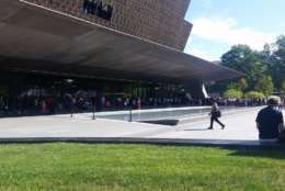 Crowds form outside of the National Museum of African American History and Culture. (WTOP/Kathy Stewart)  