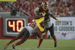 Washington Redskins running back Mack Brown (34) goes airborne as he is hit by Tampa Bay Buccaneers inside linebacker Kendell Beckwith (51) and defensive back Robert McClain (36) during the second quarter of an NFL preseason football game Thursday, Aug. 31, 2017, in Tampa, Fla. (AP Photo/Phelan Ebenhack)