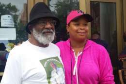 Dick Gregory's younger brother, Ron Gregory, poses with a fan of the late comedian. Juanice Johnson says she loved Gregory's humor. (WTOP/Kathy Stewart)