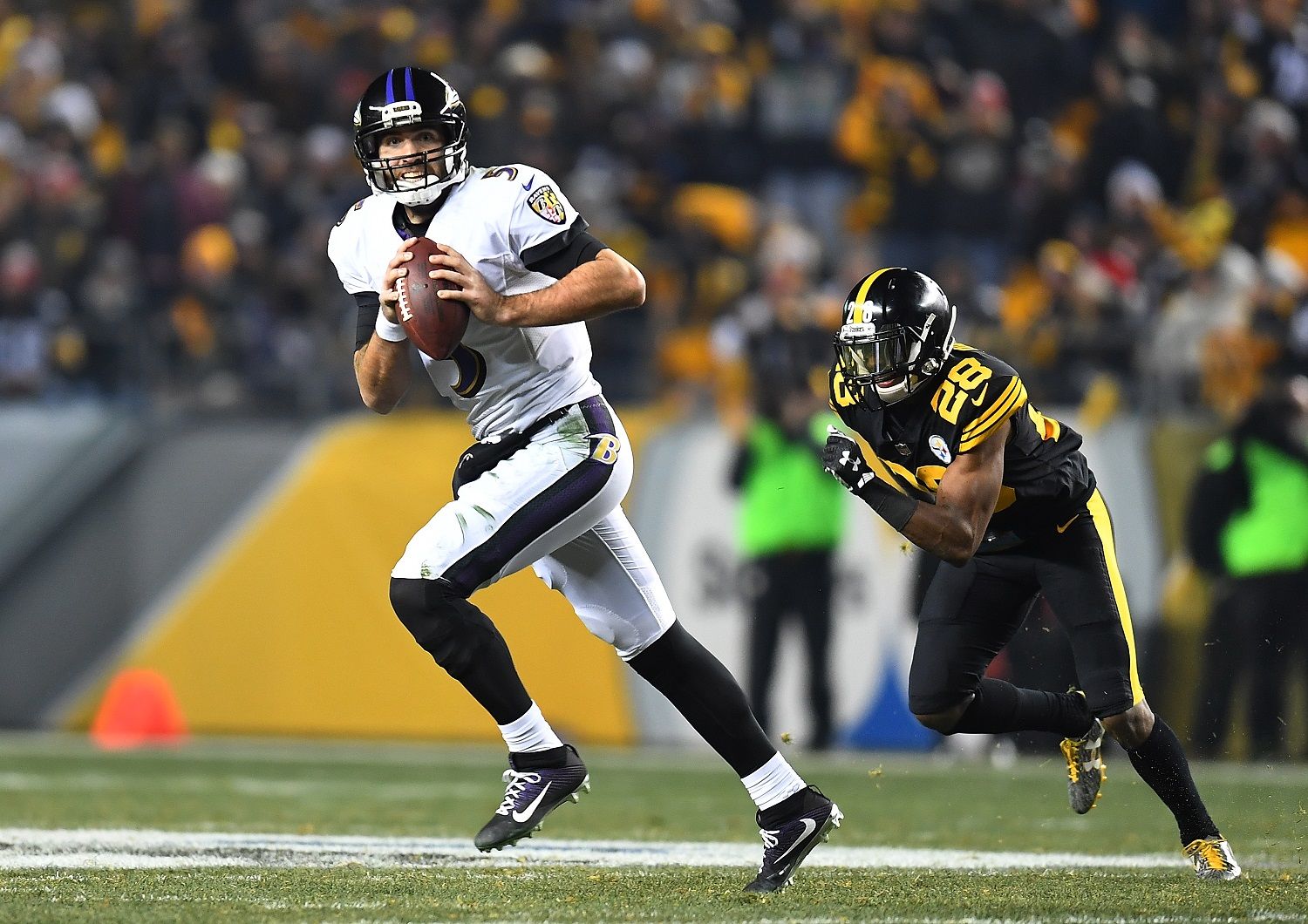 PITTSBURGH, PA - DECEMBER 25:  Joe Flacco #5 of the Baltimore Ravens scrambles to avoid the oncoming rush of Sean Davis #28 of the Pittsburgh Steelers during the game at Heinz Field on December 25, 2016 in Pittsburgh, Pennsylvania. (Photo by Joe Sargent/Getty Images)