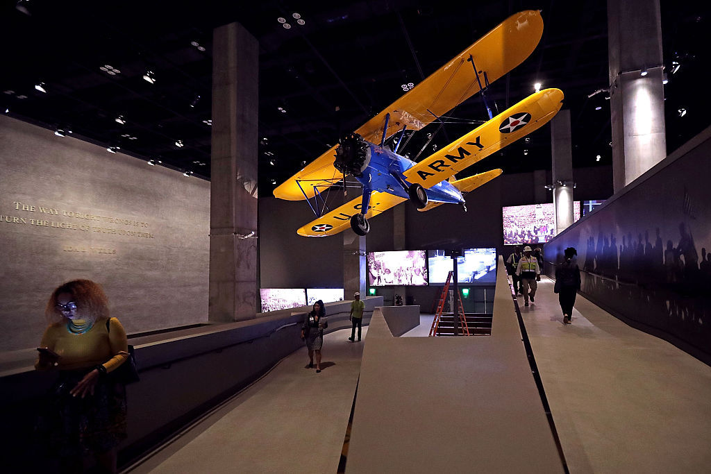WASHINGTON, DC - SEPTEMBER 14: The Spirit of Tuskegee, a PT-13 Stearman biplane flown by Tuskegee Airmen training to fight in WWII, hangs from the ceiling above the concourse galleries at the Smithsonian's National Museum of African American History and Culture on the National Mall September 14, 2016 in Washington, DC. Filled with exhibits and artifacts telling the story of the first Africans in the United States and their descendents, the 400,000-square-foot museum will open to the public on September 24. (Photo by Chip Somodevilla/Getty Images)