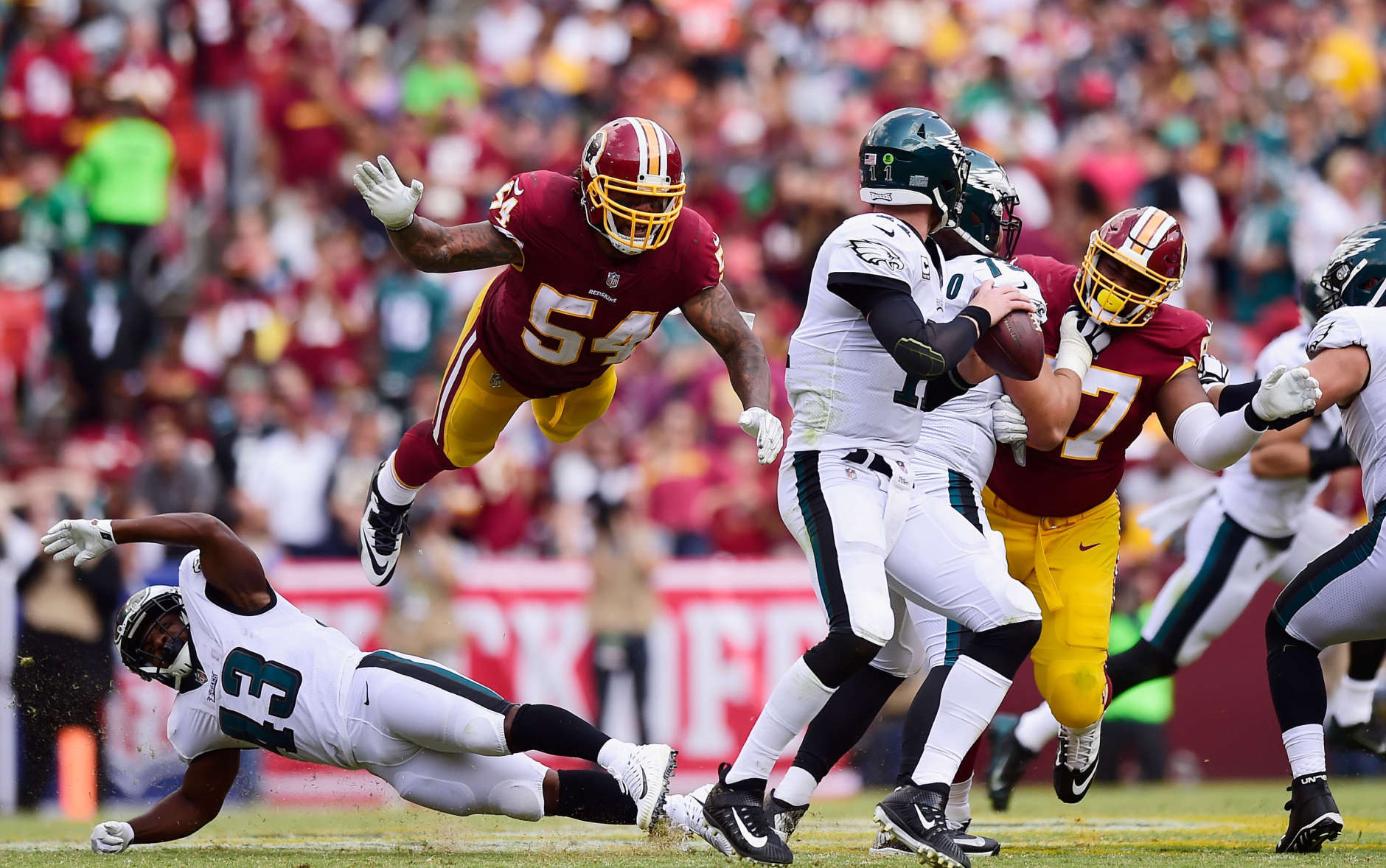 LANDOVER, MD - SEPTEMBER 10: Mason Foster #54 of the Washington Redskins flys in the air to tackle Quarterback Carson Wentz #11 of the Philadelphia Eagles in the fourth quarter at FedExField on September 10, 2017 in Landover, Maryland.  (Photo by Patrick McDermott/Getty Images)