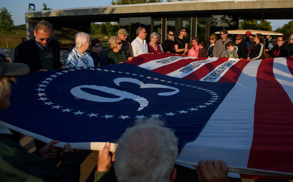 SHANKSVILLE, PA - SEPTEMBER 10: Visitors unfurl a commemorative flag at the Flight 93 National Memorial on the 16th Anniversary ceremony of the September 11th terrorist attacks, September 10, 2017 in Shanksville, PA. United Airlines Flight 93 crashed into a field outside Shanksville, PA with 40 passengers and 4 hijackers aboard on September 11, 2001. (Photo by Jeff Swensen/Getty Images)