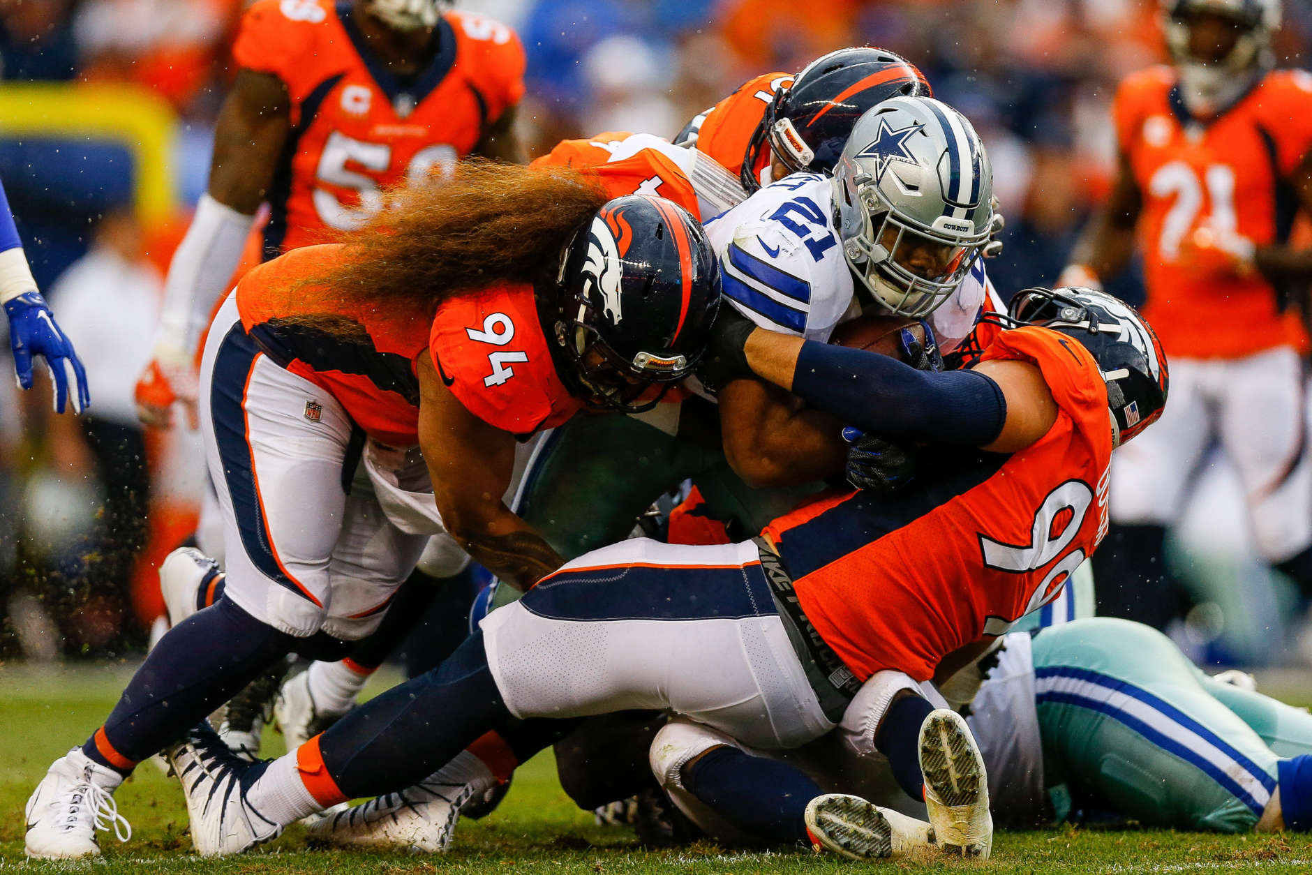 DENVER, CO - SEPTEMBER 17:  Nose tackle Domata Peko #94 and defensive tackle Adam Gotsis #99 of the Denver Broncos tackle running back Ezekiel Elliott #21 of the Dallas Cowboys in the first half at Sports Authority Field at Mile High on September 17, 2017 in Denver, Colorado. (Photo by Justin Edmonds/Getty Images)