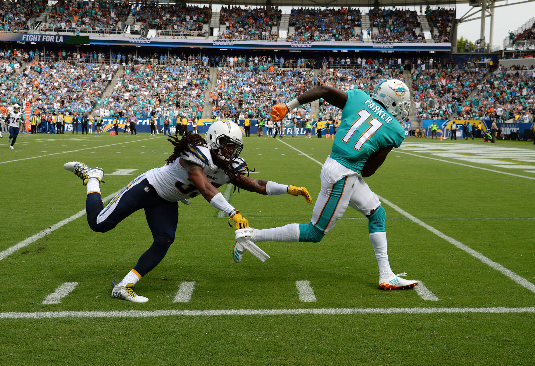 CARSON, CA - SEPTEMBER 17: Wide receiver DeVante Parker #11 of the Miami Dolphins slips past free safety Tre Boston #33 of the Los Angeles Chargers as he makes a catch and runs for big gain during the second half of their NFL game at the StubHub Center September 17, 2017, in Carson, California. (Photo by Kevork Djansezian/Getty Images)