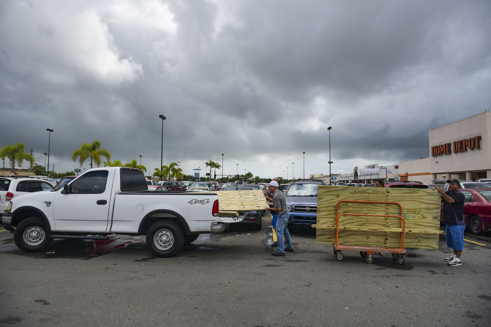 Men load recently purchased wood panels to be used for boarding up windows in preparation for Hurricane Irma, in Carolina, Puerto Rico, Tuesday, Sept. 5, 2017. Irma grew into a dangerous Category 5 storm, the most powerful seen in the Atlantic in over a decade, and roared toward islands in the northeast Caribbean Tuesday. (AP Photo/Carlos Giusti)