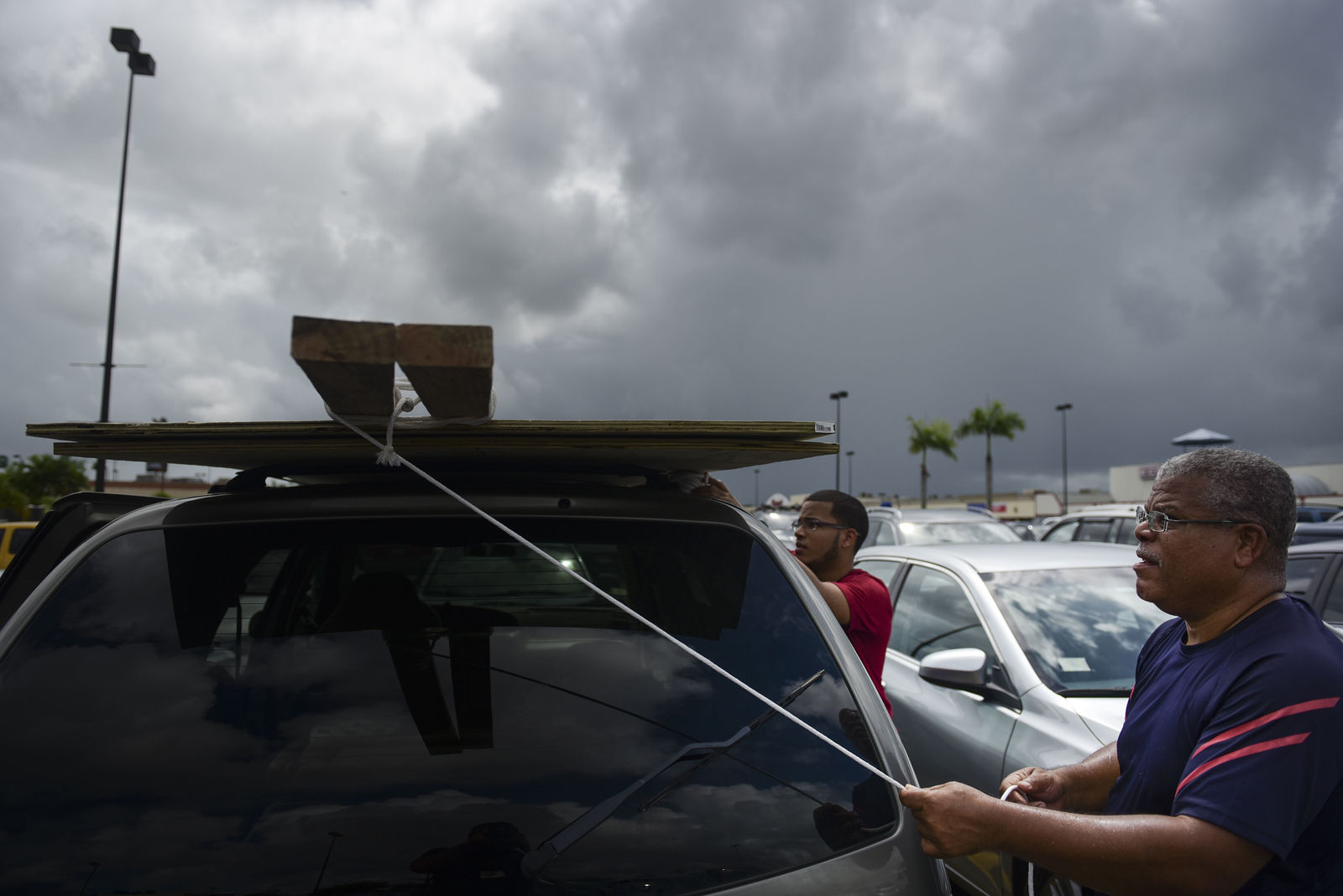Men tie down wood panels to be used for boarding up windows in preparation for Hurricane Irma, in Carolina, Puerto Rico, Tuesday, Sept. 5, 2017. Irma grew into a dangerous Category 5 storm, the most powerful seen in the Atlantic in over a decade, and roared toward islands in the northeast Caribbean Tuesday. (AP Photo/Carlos Giusti)
