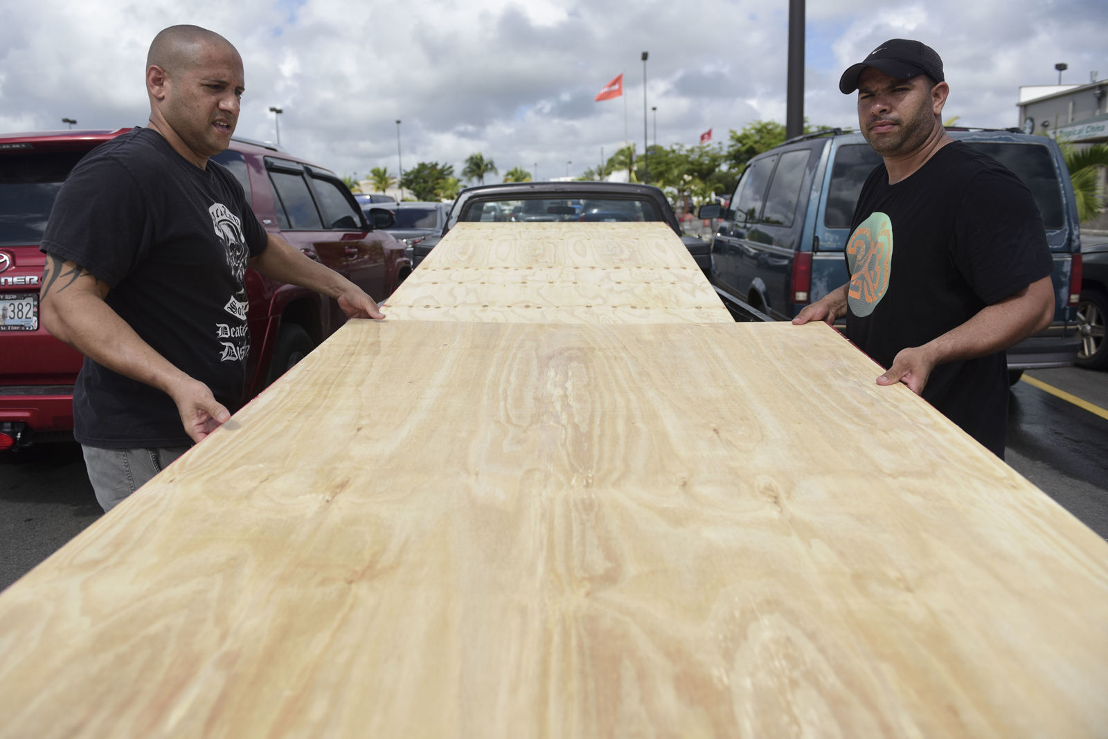 Luis Enrique Garcia, left, and Jose Rivera, load wood panels to be used for boarding up windows in preparation for Hurricane Irma, in Carolina, Puerto Rico, Tuesday, Sept. 5, 2017. Irma grew into a dangerous Category 5 storm, the most powerful seen in the Atlantic in over a decade, and roared toward islands in the northeast Caribbean Tuesday. (AP Photo/Carlos Giusti)