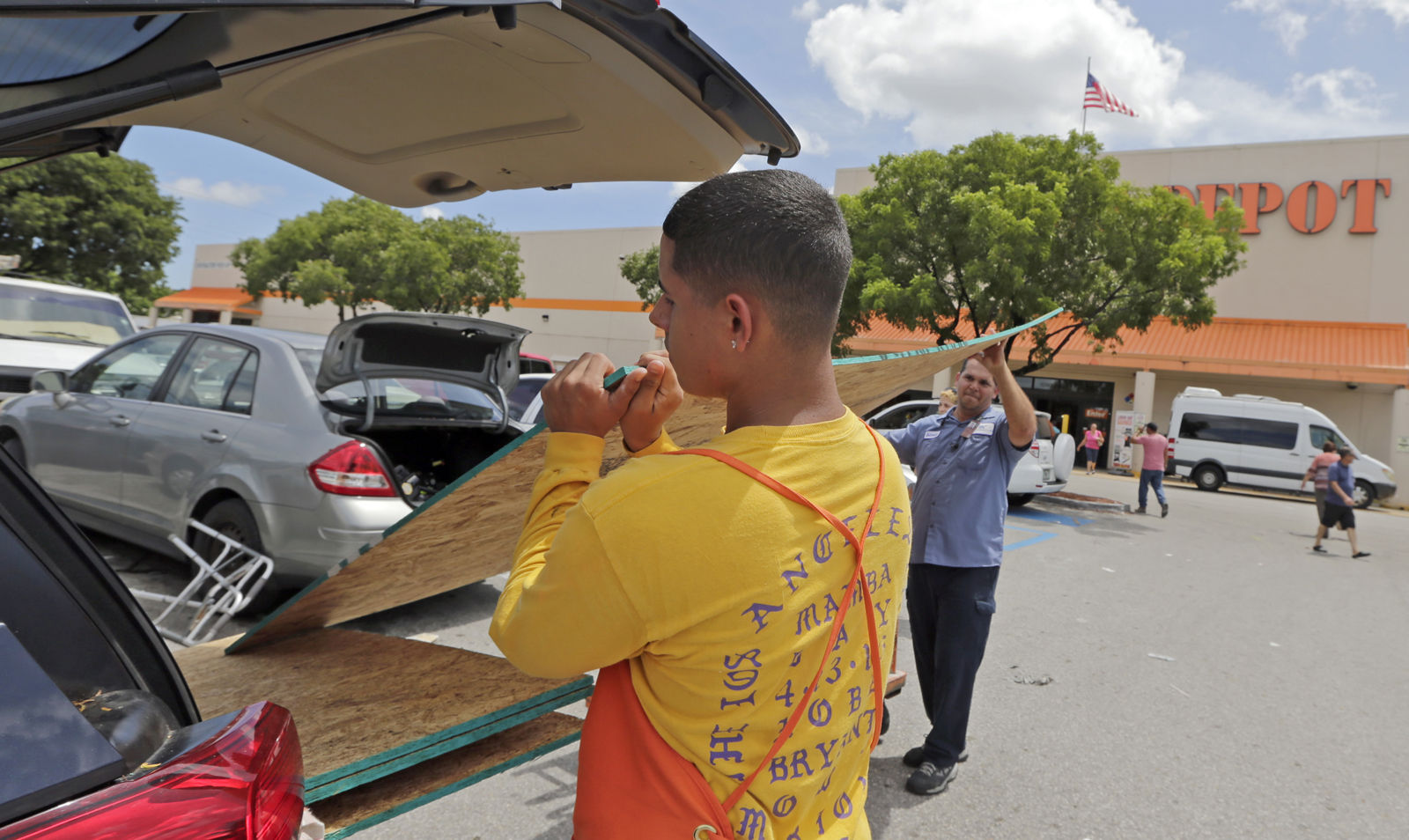 Home Depot employee Fernando Garlobo, left, helps Adrielys Estrada load a sheet of strand board on a van as residents prepare for Hurricane Irma in Hialeah, Fla. Hurricane Irma grew into a dangerous Category 5 storm, the most powerful seen in the Atlantic in over a decade, and roared toward islands in the northeast Caribbean Tuesday on a path that could eventually take it to the United States. (AP Photo/Alan Diaz)