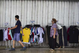 Residents walk past a storefront, paneled with steel sheets in preparation for Hurricane Irma, in Carolina, Puerto Rico, Tuesday, Sept. 5, 2017. Irma grew into a dangerous Category 5 storm, the most powerful seen in the Atlantic in over a decade, and roared toward islands in the northeast Caribbean Tuesday. (AP Photo/Carlos Giusti)