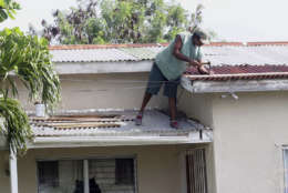 A homeowner makes last minute repairs to his roof in preparation for Hurricane Irma, in St. John's, Antigua and Barbuda, Tuesday, Sept. 5, 2017.  Irma grew into a dangerous Category 5 storm, the most powerful seen in the Atlantic in over a decade, and roared toward islands in the northeast Caribbean Tuesday on a path that could eventually take it to the United States. (AP Photo/Johnny Jno-Baptiste)