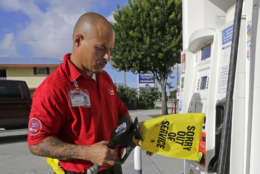 Gas station employee Albert Fernandez covers a pump after running out of gas as the demand for gas has increased due to Hurricane Irma, Wednesday, Sept. 6, 2017, in Key Largo, Fla.  Irma roared into the Caribbean with record force early Wednesday, its winds shaking homes and flooding buildings on a chain of small islands along a path toward Puerto Rico, the Dominican Republic, Haiti, Cuba and likely Florida by the weekend. (AP Photo/Alan Diaz)