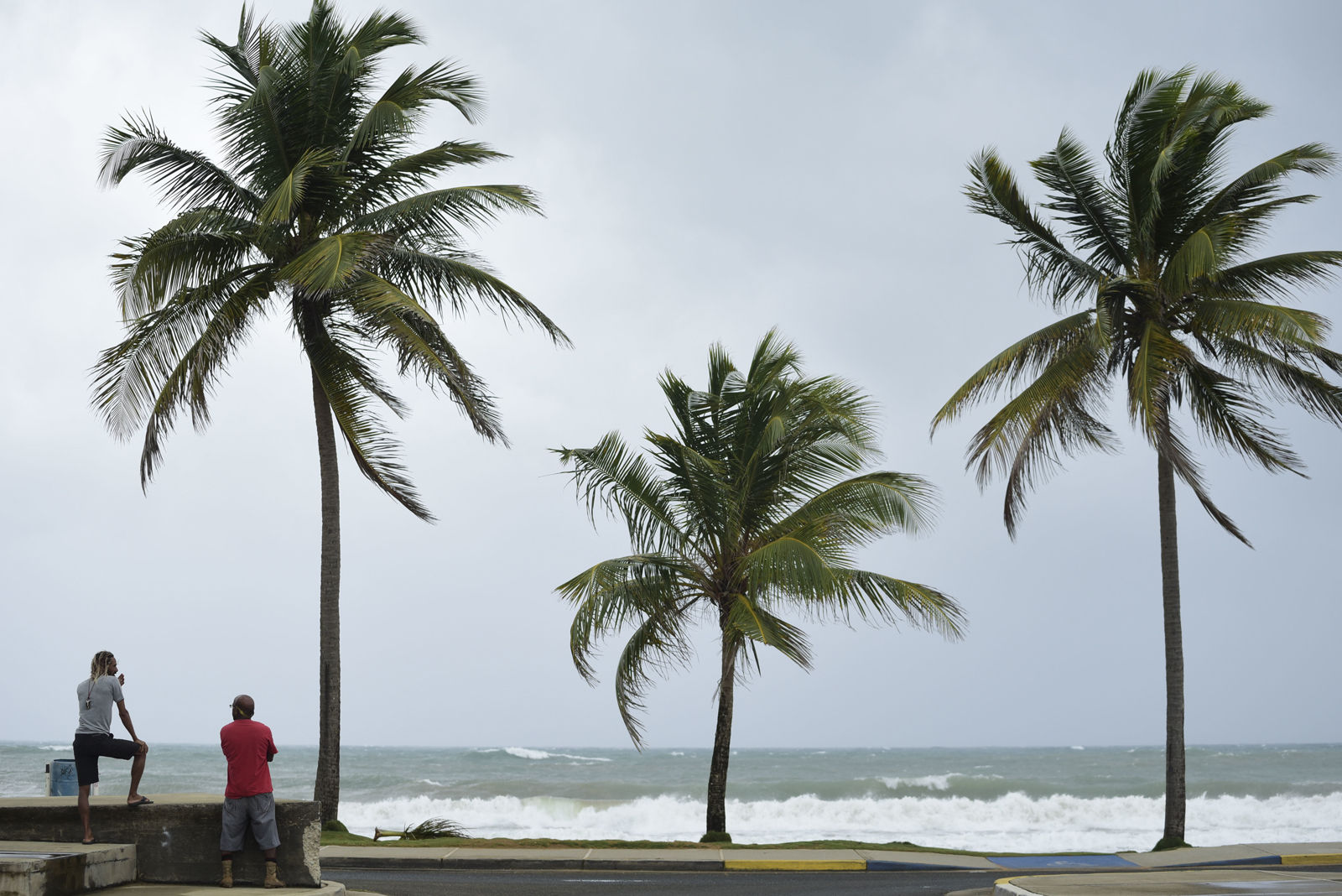 People stand near the shore before the arrival of Hurricane Irma, in luquillo, Puerto Rico, Wednesday, Sept. 6, 2017. Irma roared into the Caribbean with record force early Wednesday, its 185-mph winds shaking homes and flooding buildings on a chain of small islands along a path toward Puerto Rico, Cuba and Hispaniola and a possible direct hit on densely populated South Florida. (AP Photo/Carlos Giusti)