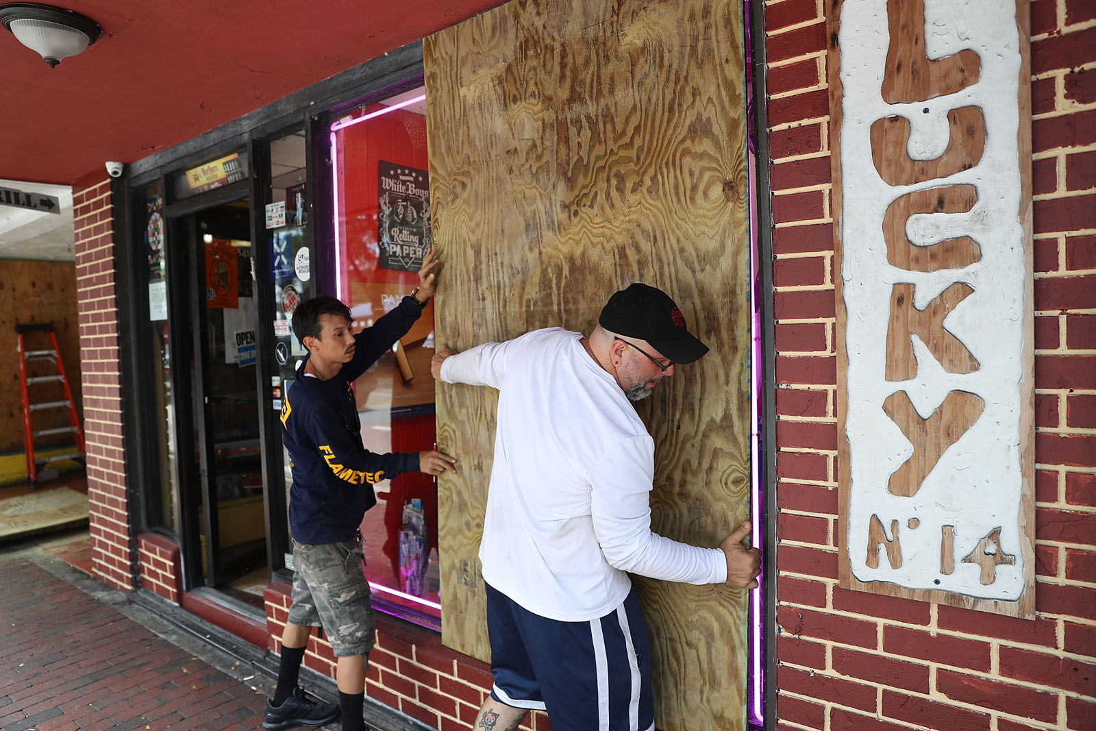 Noel Garcia and Mike Ehlis (L-R) put plywood over windows of Noel's business as they prepare for Hurricane Irma on Sept. 6, 2017 in Miami, Florida. It's still too early to know where the direct impact of the hurricane will take place but the state of Florida is in the area of possible landfall.  (Photo by Joe Raedle/Getty Images)