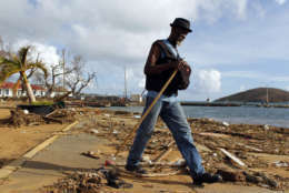 A man walks past debris caused by Hurricane Irma in Charlotte Amalie, St. Thomas, U.S. Virgin Islands, Sunday, Sept. 10, 2017.  The storm ravaged such lush resort islands as St. Martin, St. Barts, St. Thomas, Barbuda and Anguilla. (AP Photo/Ricardo Arduengo)