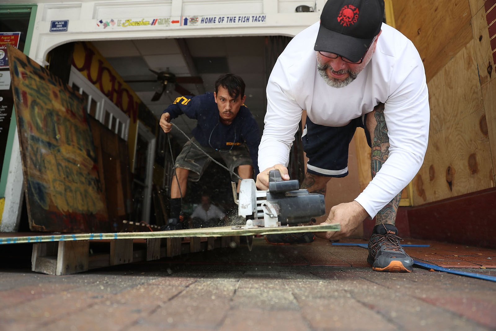 Noel Garcia and Mike Ehlis (L-R) cut plywood to place over the windows of Noel's business as they prepare for Hurricane Irma on Sept. 6, 2017 in Miami, Florida. It's still too early to know where the direct impact of the hurricane will take place but the state of Florida is in the area of possible landfall.  (Photo by Joe Raedle/Getty Images)