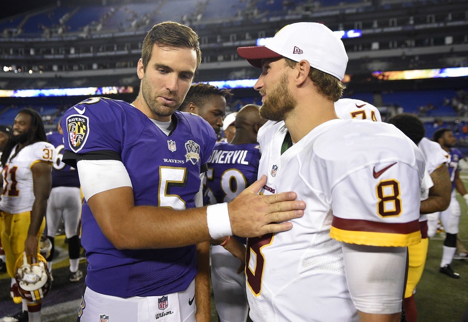 FILE - In this Aug. 29, 2015, file photo, Baltimore Ravens quarterback Joe Flacco, left, chats with Washington Redskins quarterback Kirk Cousins after a preseason NFL football game in Baltimore. If the cornerstone of a great rivalry is proximity between the teams, the Redskins and Ravens would be nasty adversaries. Both teams play their home games in Maryland at stadiums located just 32 miles apart. (AP Photo/File)