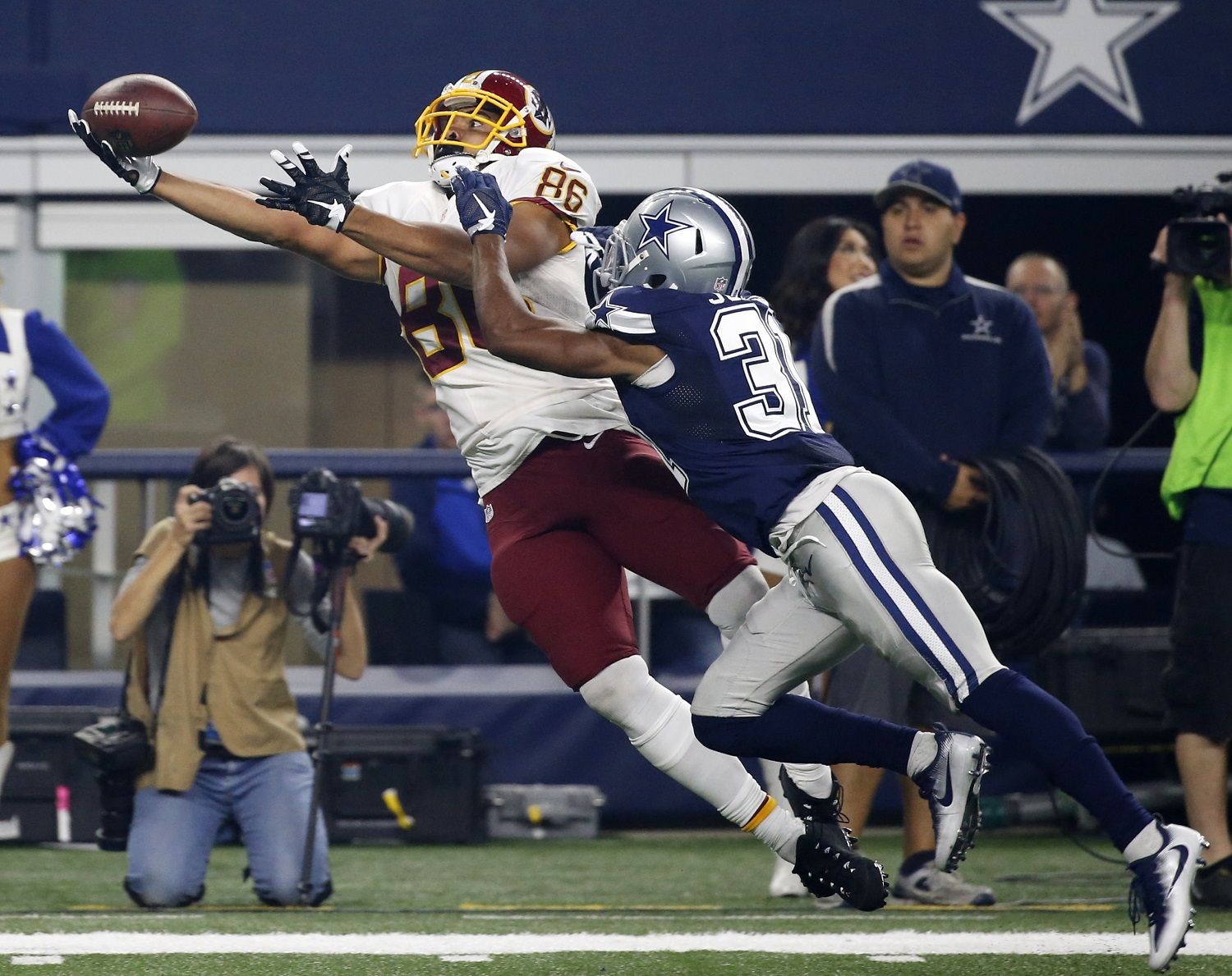 File-This Nov. 24, 2016, file photo shows Washington Redskins tight end Jordan Reed (86) laying out to catch a pass in front of Dallas Cowboys' Byron Jones (31) during the second half of an NFL football game in Arlington, Texas. Reed is back at Redskins practice after missing the first three-plus weeks of camp with a toe injury. With the first-team offense looking stagnant so far in the preseason, the big tight end's return is expected to make a major difference. (AP Photo/Michael Ainsworth, File)