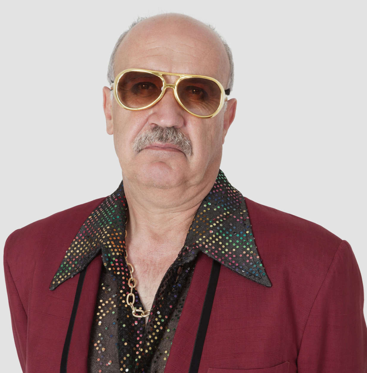 Portrait of unhappy senior man wearing sunglasses against gray background