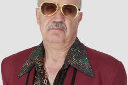 Portrait of unhappy senior man wearing sunglasses against gray background